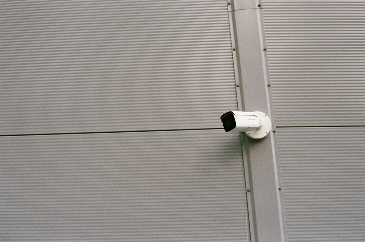 a white and black CCTV camera mounted on a wall