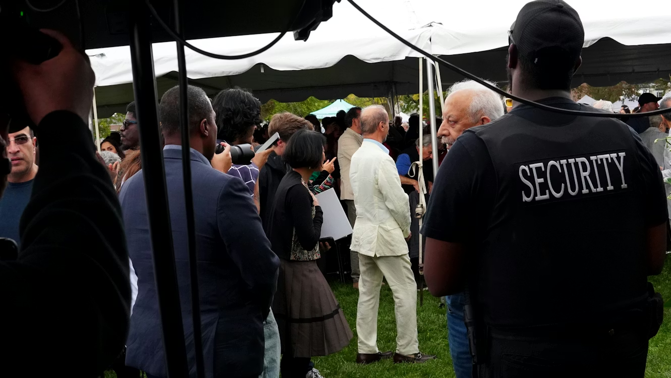 a security guard watching over a crowd of people from under a tent