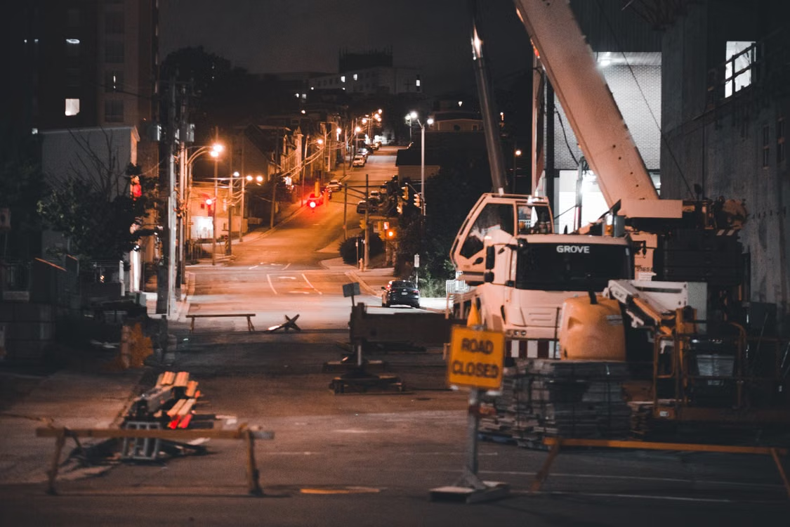  Construction site area and heavy machinery illuminated by artificial lights at night.